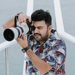 Pasrshant Photography Profile Web. He is holding a camera for stills.