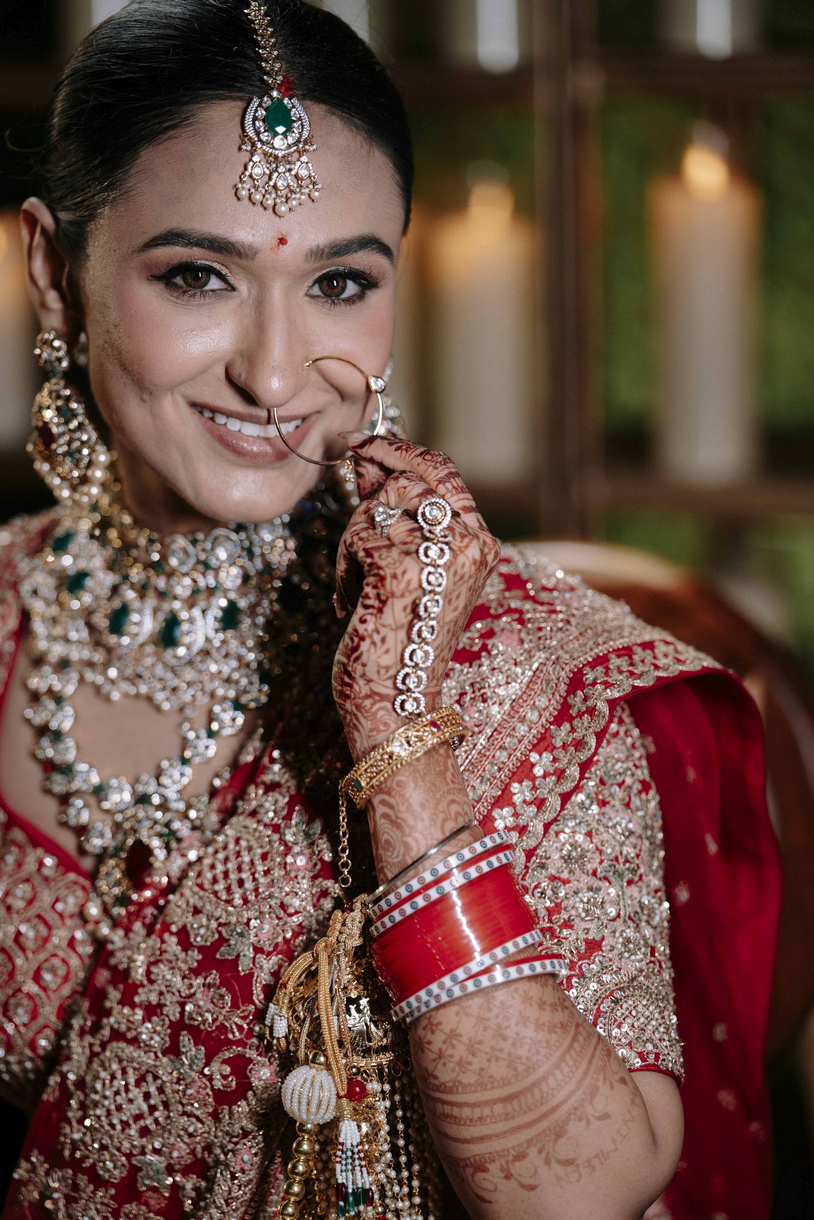 Bridegroom portrait showing her red saree, nose nath and tikka jewelery