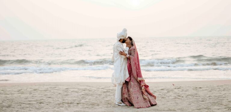 Couple on the beach in Goa kissing after their wedding